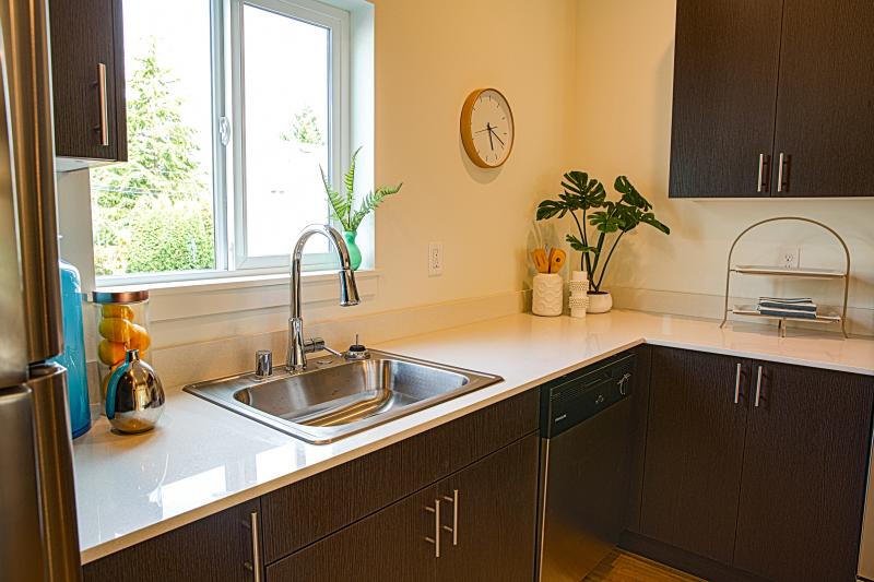 Kitchen sink with chrome faucet in front of large window