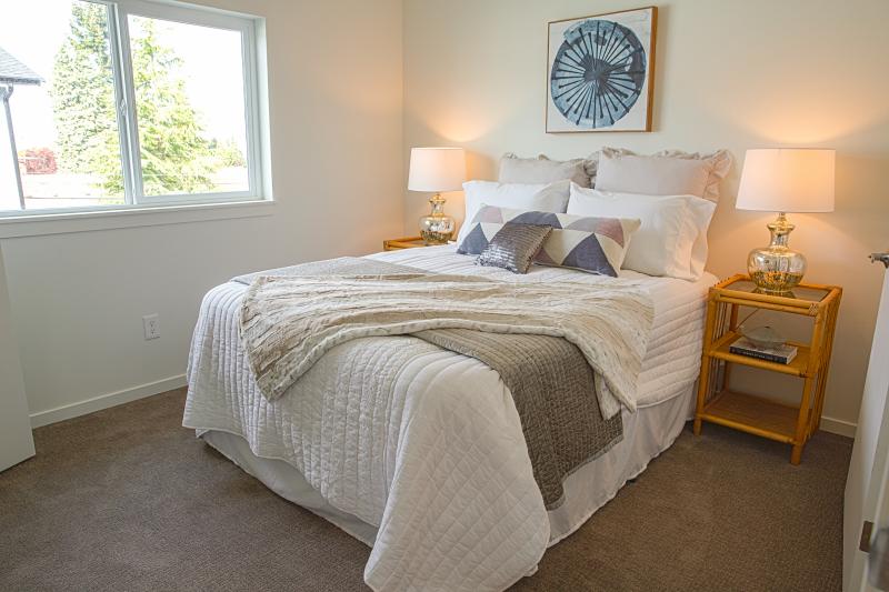 Bedroom with window, bedding, and night stand